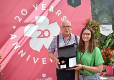 Klaas Droog houdt samen met Francesca Lanzillotta de Memorial Coin vast. Deze geeft MNP Flowers aan hun partners en licentiehouders van de Mandevilla ter ere van hun 20 jarig jubileum.